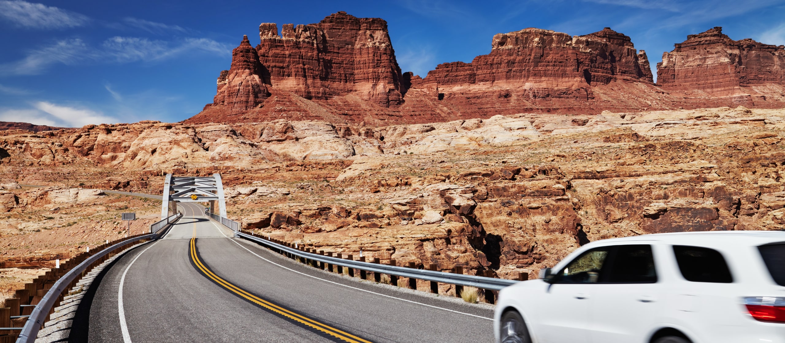 Ein Mietwagen auf einer Straße im Südwesten der USA, schroffe Felsgegend